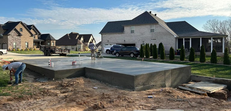 a man is working on a concrete slab in a residential area