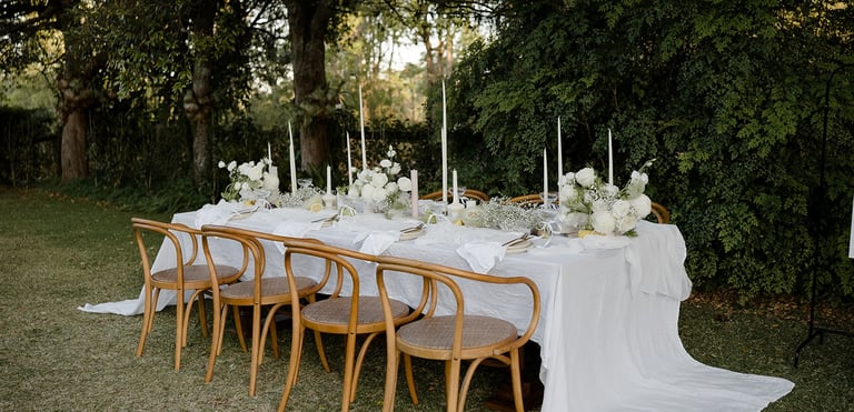 a table with a long table cloth and candles