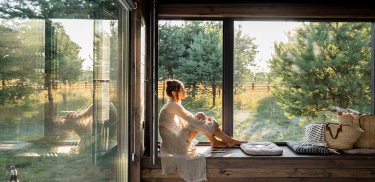 Femme paisible dans son salon en bois, évoquant le feng shui