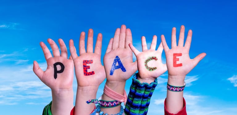 a group of people holding hands up with peace written on their hands