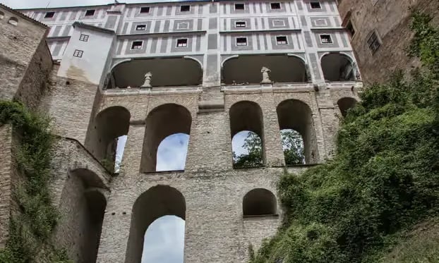 Narrow canal flowing through Český Krumlov old town with castle tower view