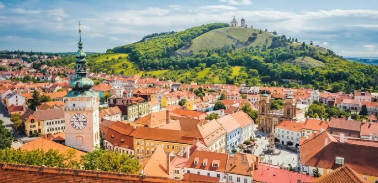 Sunny view of Mikulov main square with the historic clock tower and Holy Hill (Svaty Kopecek) South Moravia.