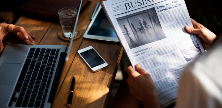 Someone reading the newspaper headlines in corporate environment
