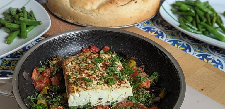 A nice brown Baked Feta Cheese with colorful veggies, topped with Chia microgreens with a crusty Rosemary Bread side dish