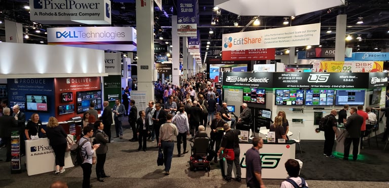 Tradeshow expo hall filled with exhibit booths and attendees.