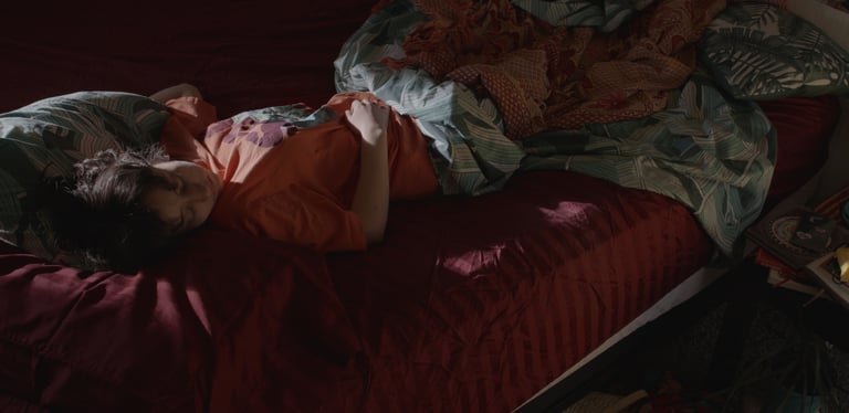 a woman laying on a bed with a blanket