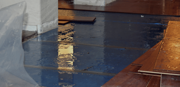 alt="Flooded floor with visible storm damage inside residential home"