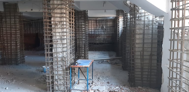 Bir yapının güçlendirme ve onarım aşamalarını gösteren fotoğraf.