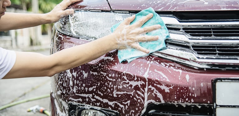 a woman is cleaning a car with a cloth