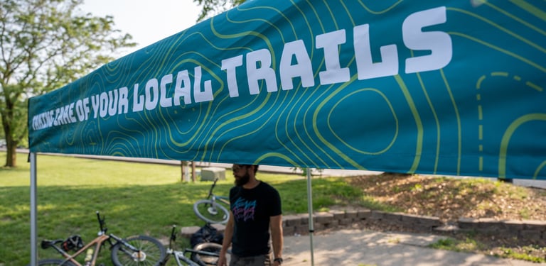 Someone standing under the COMOTA tent with bikes laying on the ground