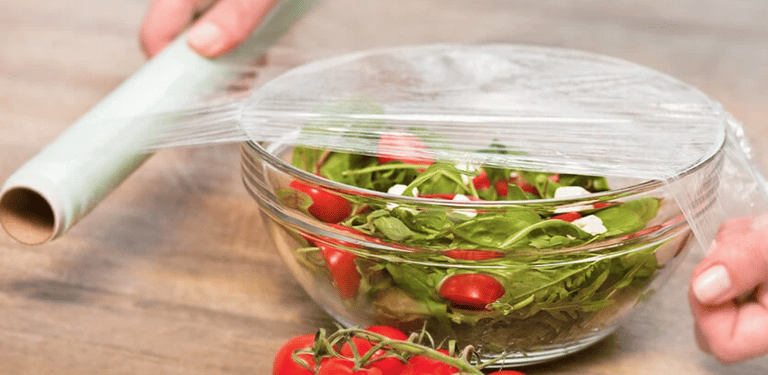 a person is holding a plastic container with tomatoes
