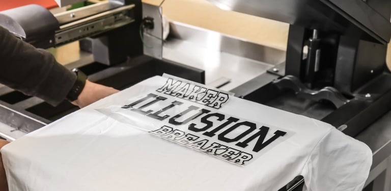 A heat press machine applying a custom vinyl decal to a white t-shirt in a printing shop.