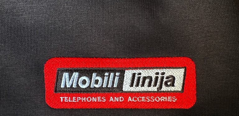Close-up of a black sweatshirt featuring an embroidered Mobili linija logo in red and white.