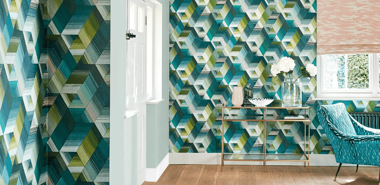 Modern living room featuring geometric teal and green patterned wallpaper with a gold console table.
