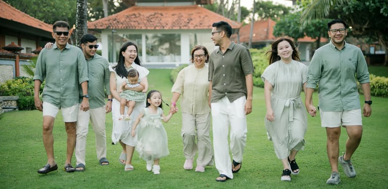 Multigenerational family walking together through a tropical garden during a Bali family photography session.