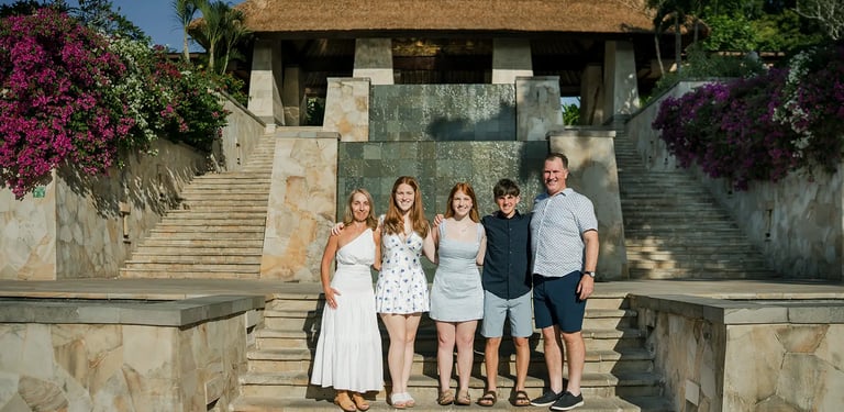 Family portrait at the iconic entrance of AYANA Resort Bali during a luxury family photography session
