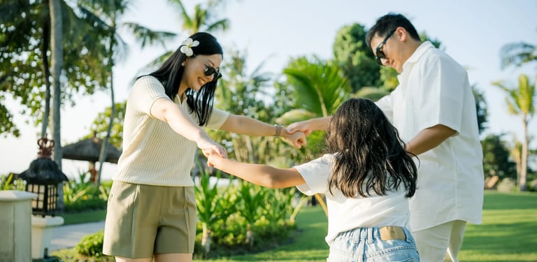 Family playing together on the lawn during a family photography session at InterContinental Bali Resort