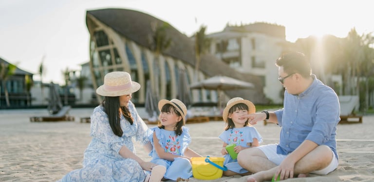 Family playing together on the beach at The Apurva Kempinski Bali.