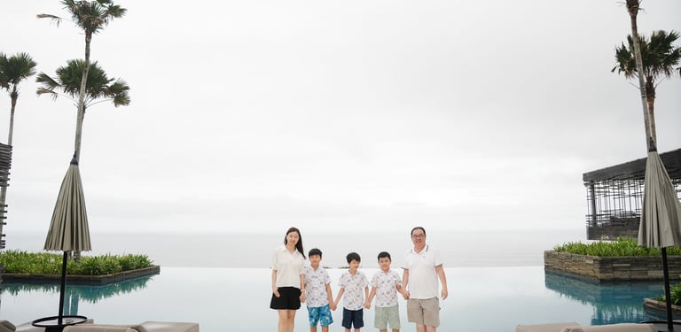Extended family wide shot at Alila Villas Uluwatu Bali with ocean horizon and architectural symmetry