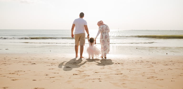 family session Jimbaran Beach Bali parents walking with child at sunset beach