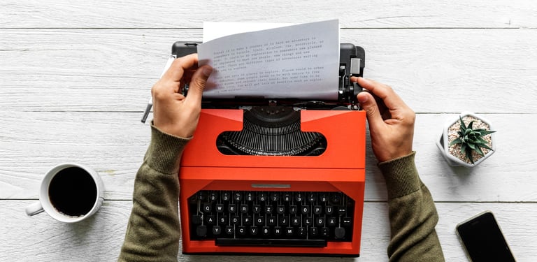 A writer typing on a typewriter, with a focus on the writing process and content creation.