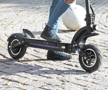 a person riding a scooter on a cobblestone