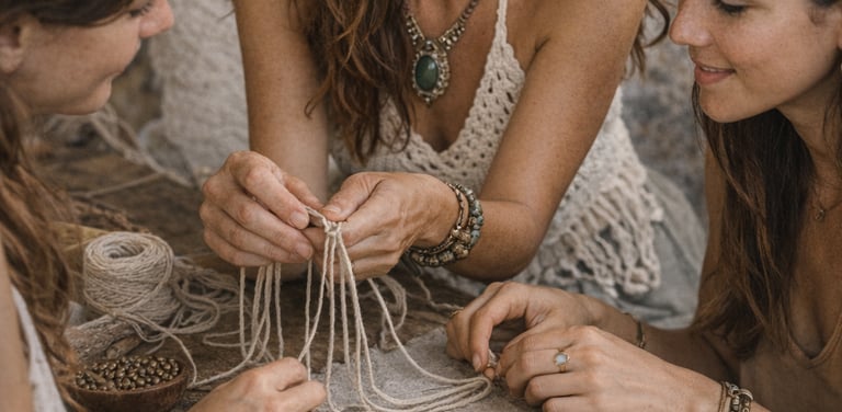 Tres mujeres reunidas en una mesa de madera rústica participando en un taller bohemio de macramé 