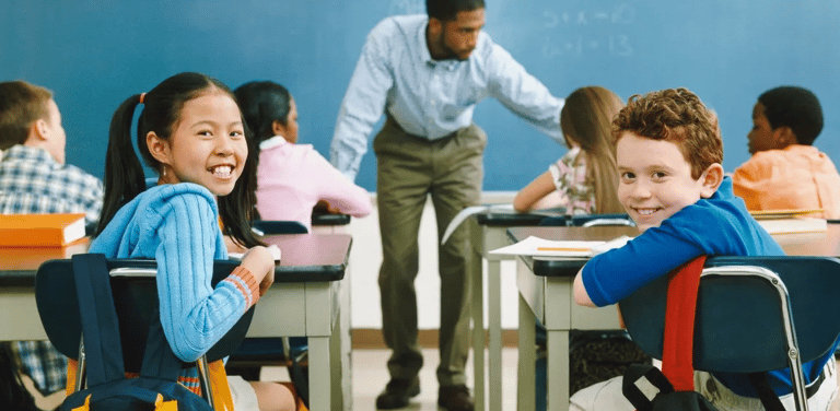 a man standing in front of a classroom with a group of children