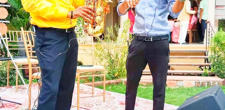 Professional musicians performing with a golden saxophone and red violin at an outdoor event.