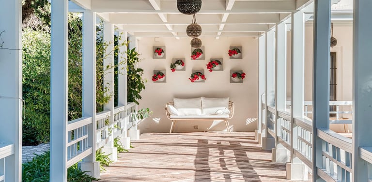 Shaded pergola walkway with lanterns and floral wall detail
