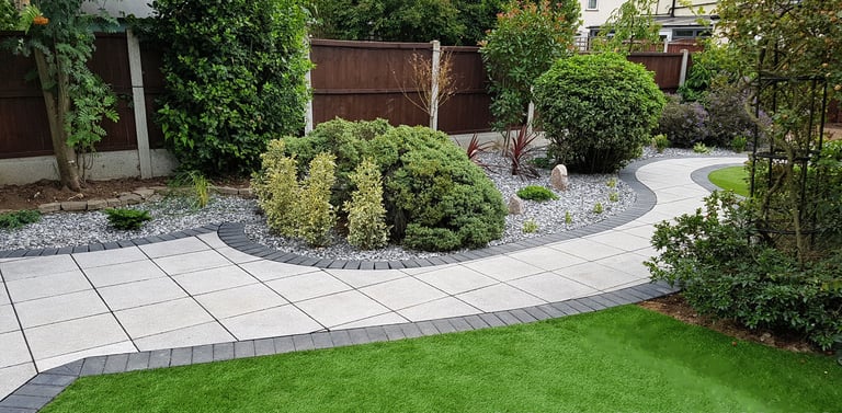 Patio with custom stone circle with aggregates and paving weaving through adventurous garden design
