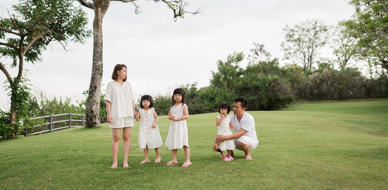 Natalia family enjoying a relaxed moment together on the green lawn at The Mulia Nusa Dua Bali