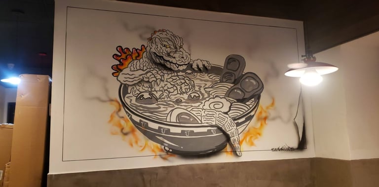 Anime image of a monster in a bowl of ramen painted on the wall of a restaurant.