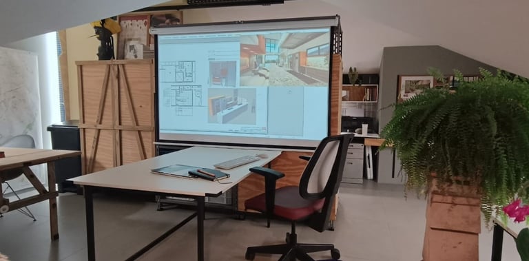 ala com mesa de trabalho e projeção de projeto arquitetônico no estúdio Arqmaisart