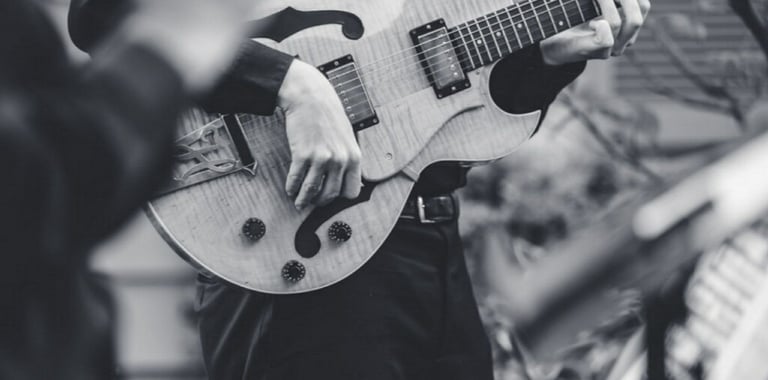 a black and white photo of a man playing guitar 
