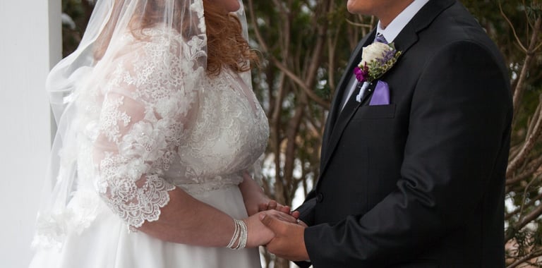 a bride and groom standing in front of a white house