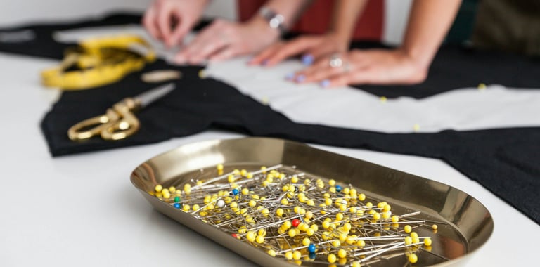 agujas tijeras metros y personas haciendo una prenda