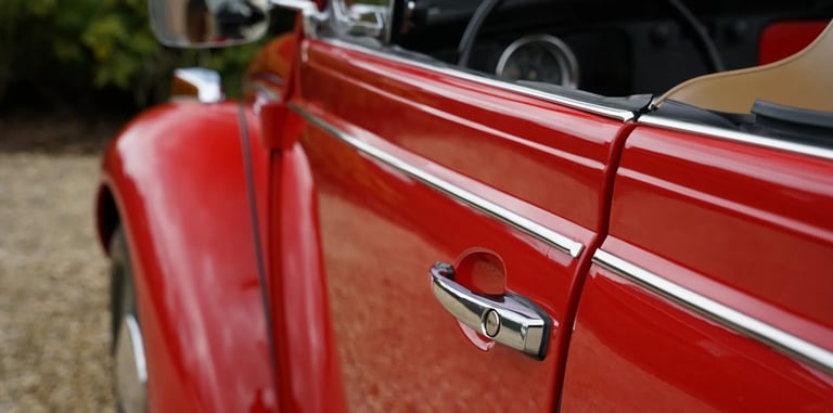 Detalle puerta cromada del Volkswagen Beetle Cabriolet rojo 1971, clásico elegante de alquiler para bodas.
