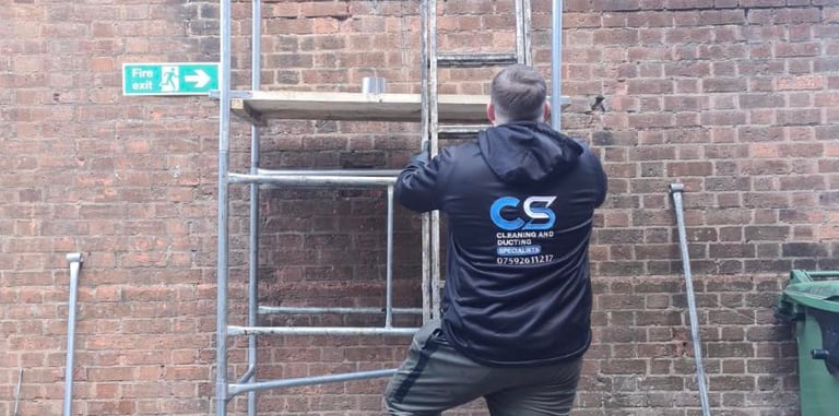 a man in cs cleaning and ducting company workwear fixing ducting