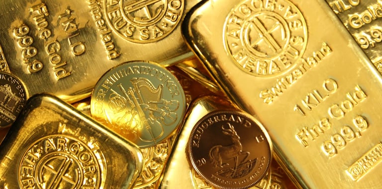 A collection of shiny 1 kilogram Argor-Heraeus gold bars and gold bullion coins for investment.
