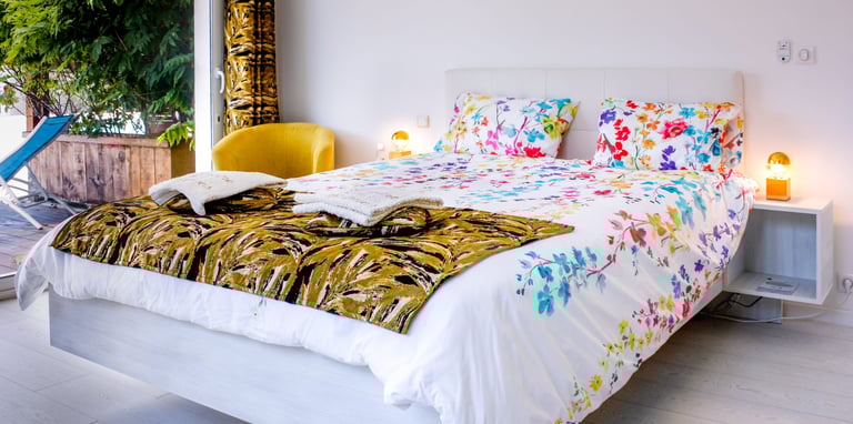 Bed with full bedding, floating bed with two with swimming pool in flower colours at Domaine Des Lucques
