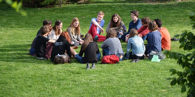 Groupe de personnes assis en cercle sur l'herbe