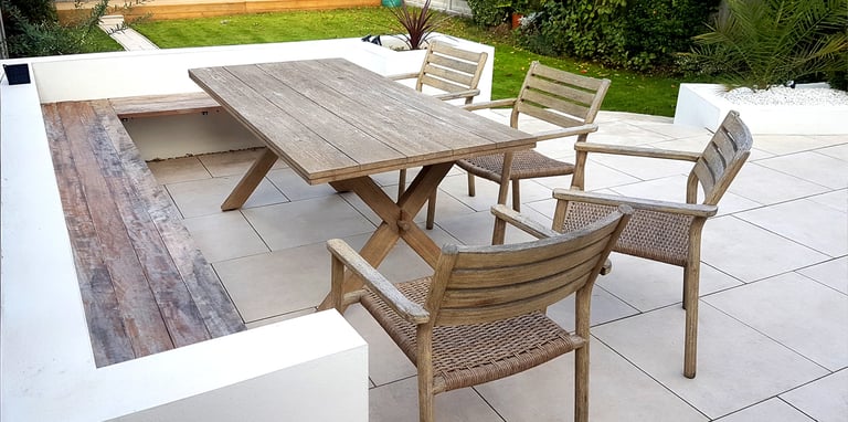 Modern chic raised porcelain patio with white rendered walls and planters
