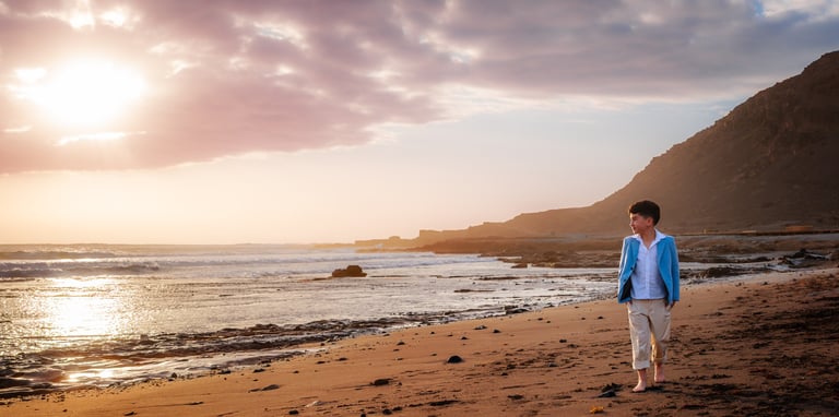 a man walking on a beach with a dog