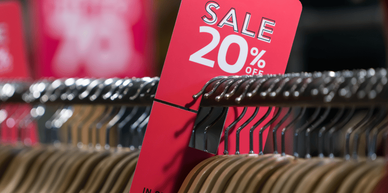 Sale sign on a rack of clothing to symbolise AI in retail