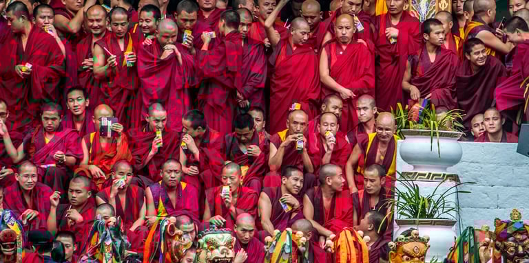 Masked-dancer-with-Monks-in-The-Backdrop-in-Thimphu