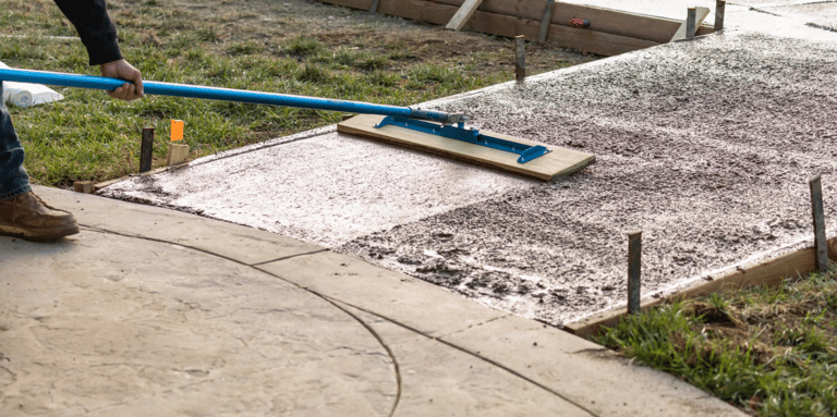 a man is using a blue broom to clean the concrete