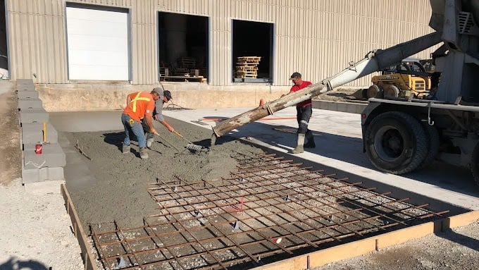 a man is pouring concrete into a concrete slab
