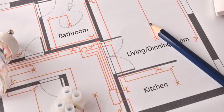 Residential electrical blueprint with pencil and wiring connectors for home renovation planning.