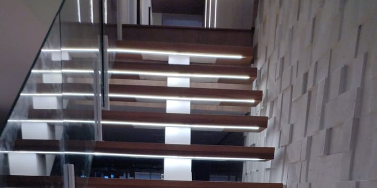 Vista de cima para baixo dos degraus de madeira de uma escada flutuante, destacando a iluminação de LED embutida em cada degr